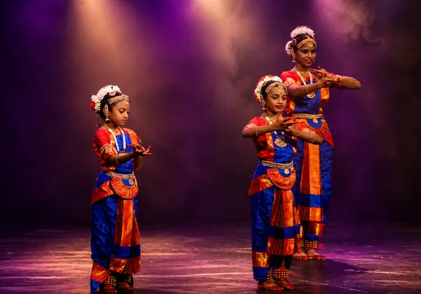 Three young Bharatanatyam students practicing adavus on stage at Spotlight Academy, The Woodlands TX