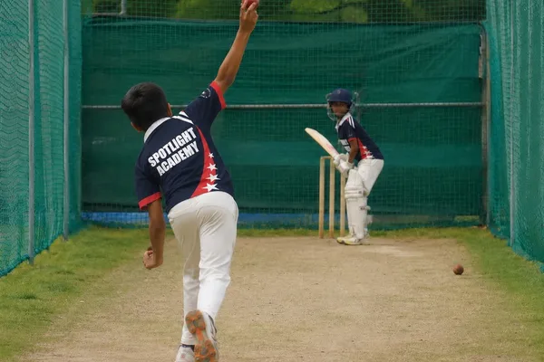 Spotlight Academy cricket student bowling in outdoor practice nets with batter at the crease, The Woodlands TX